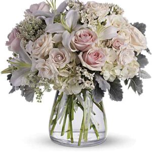 Pink and white rose arrangement in hurricane vase